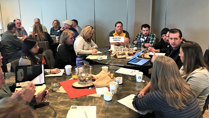 a group of people sit around a meeting table