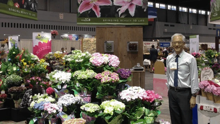 Bay City Flower Company is a fourth-generation family-owned business. Harrison Higaki, owner and President of Bay City Flower Company, is seen here next to their array of colorful hydrangeas.