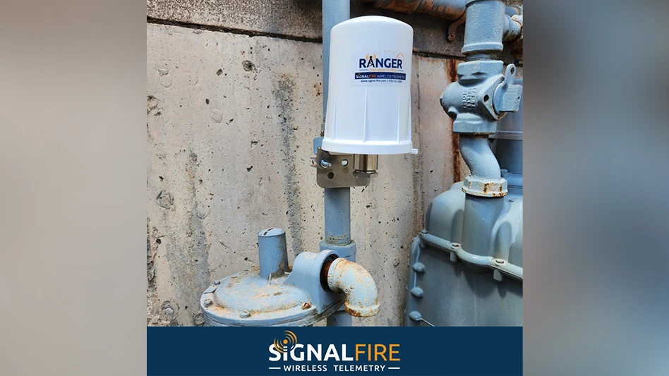A white plastic cylinder on a gray metal pipe against a concrete wall. A white and orange logo on a navy background at the bottom of the photo reads SignalFire Wireless Telemetry.
