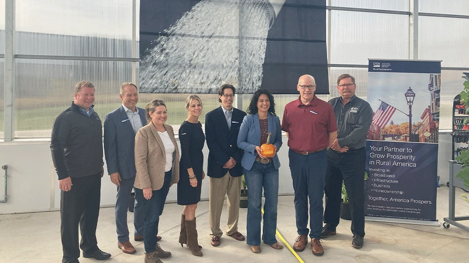 A group of eight people smile and pose for a photo.