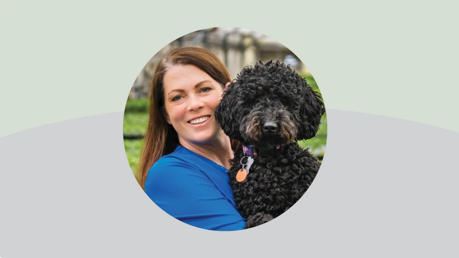 A graphic with a green and gray background. In the middle is a circular photo of a smiling woman with long brown hair wearing a blue top and holding a curly black dog.