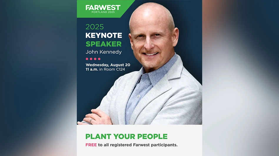 A headshot photo of a smiling bald man wearing a white blazer.