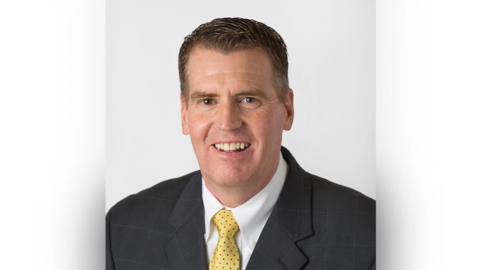 A smiling man in a suit posing for a headshot photo.
