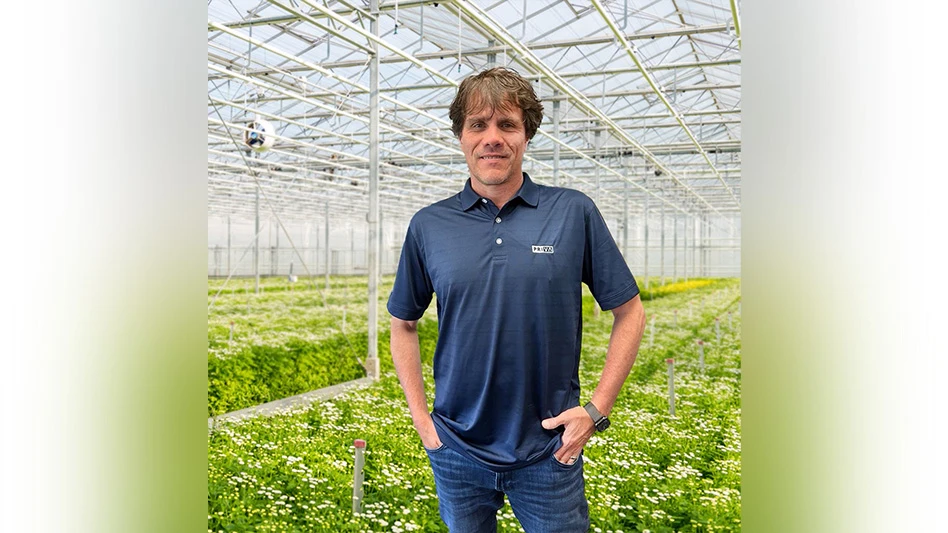 Man poses inside of greenhouse