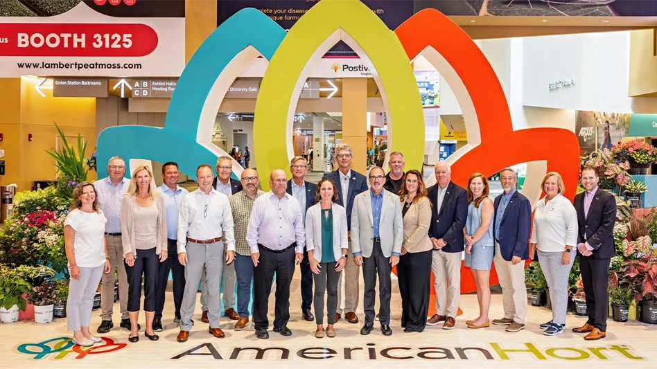 Group of people posed at a booth with large AmericanHort letters in front of them.