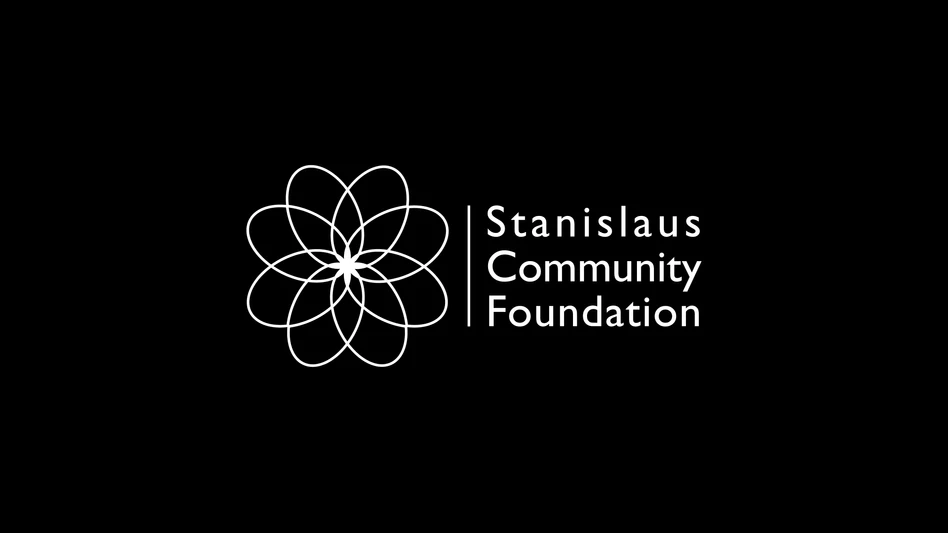 A white logo reading Stanislaus Community Foundation on a black background.